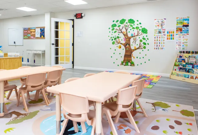 An inside of a play school with tables, chairs and more