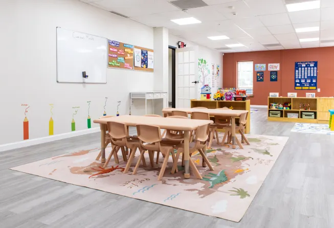 An inside of a play school with tables, chairs and more