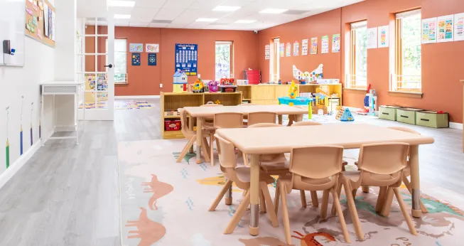 An inside of a play school with tables, chairs and more